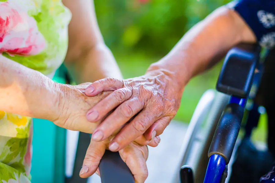 nærbilde av to mennesker sine hender der den ene holder den ene hånda over en annens hånd