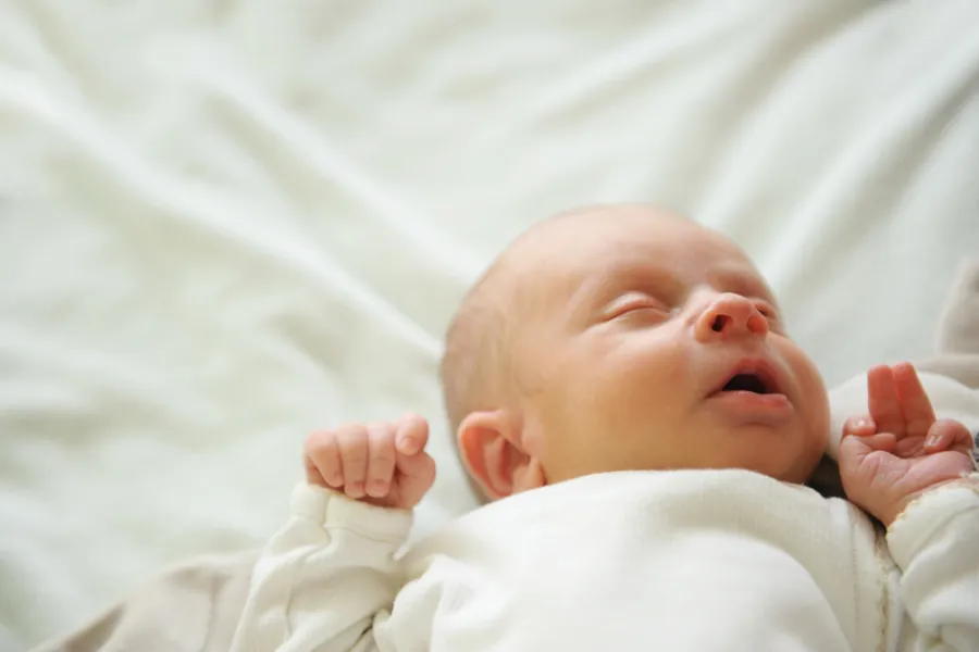 Ein baby som ligg på ryggen
