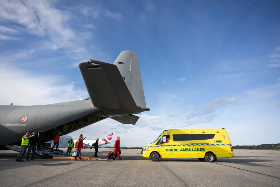 En gruppe mennesker som står ved siden av et fly