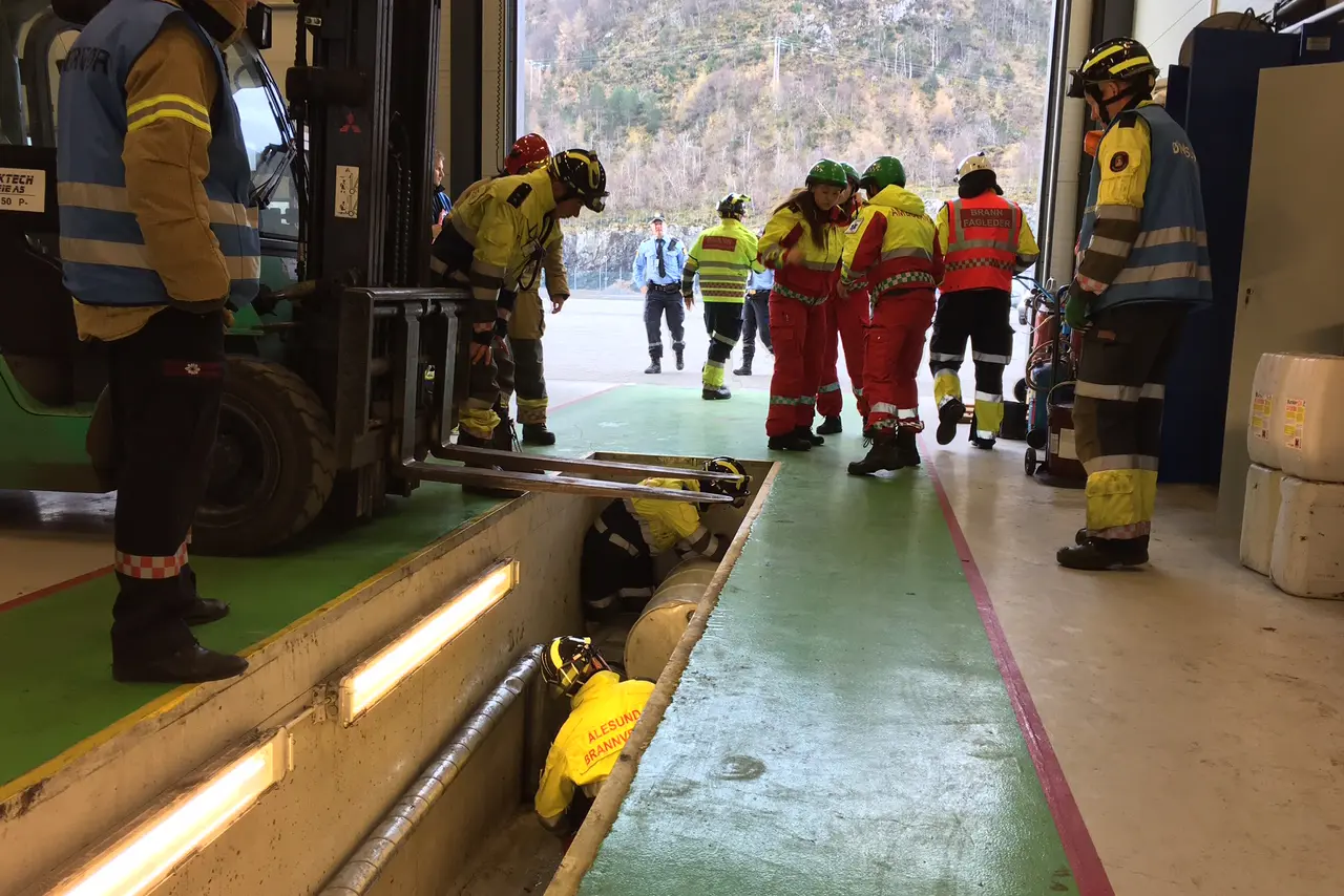 En gruppe brannmenn som står ved siden av en brannbil