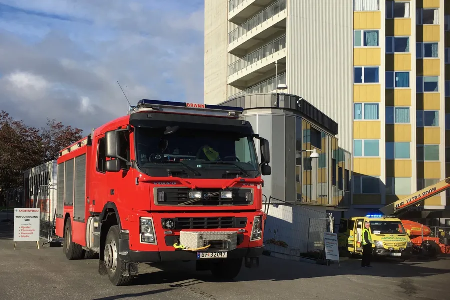 En rød lastebil parkert utenfor en bygning