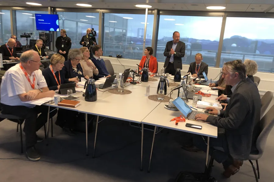 En gruppe mennesker som sitter ved et bord med bærbare datamaskiner