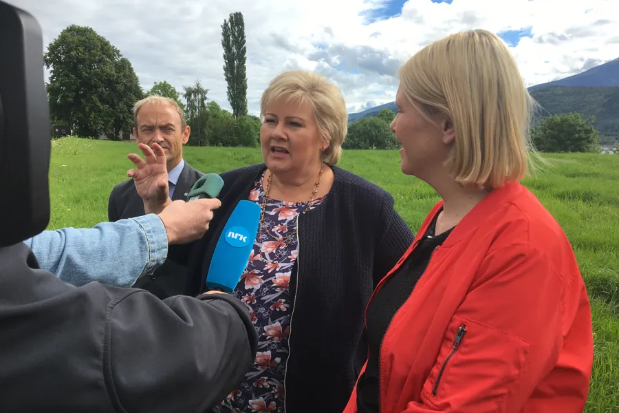 En gruppe mennesker som sitter på en benk i en park