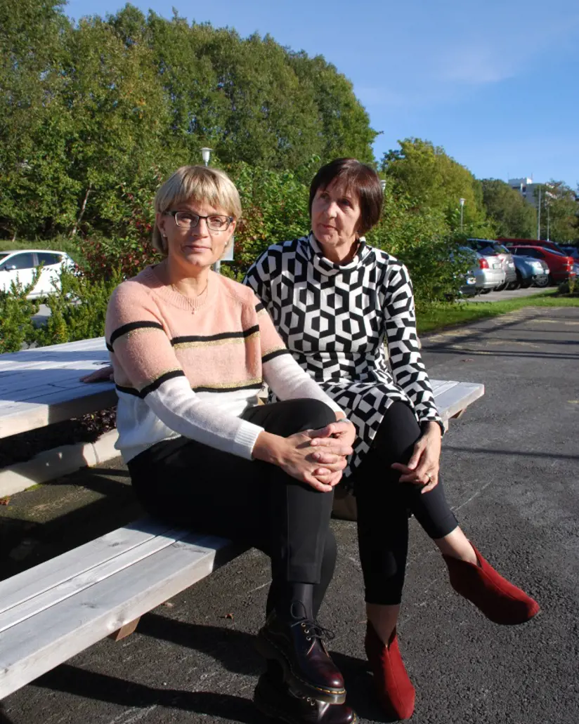 To kvinner som sitter på en benk