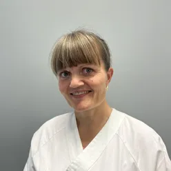 En person som smiler med en hvit skjorte