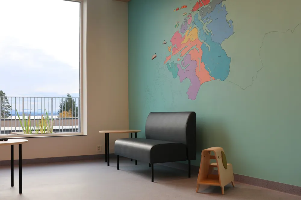 A room with a chair and a table with a map on the wall