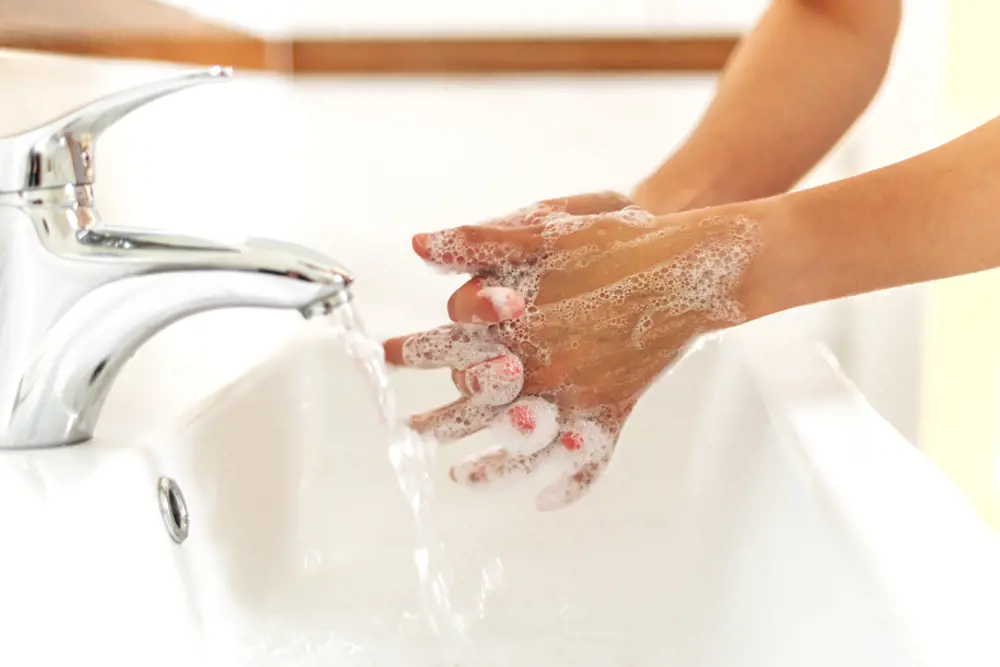Nærbilde av hender som blir vaska med såpe.