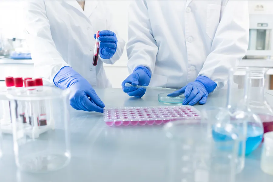 Forskere i hvite frakker som tester vaksine i et laboratorium