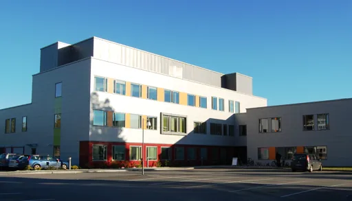 En bygning med biler parkert foran