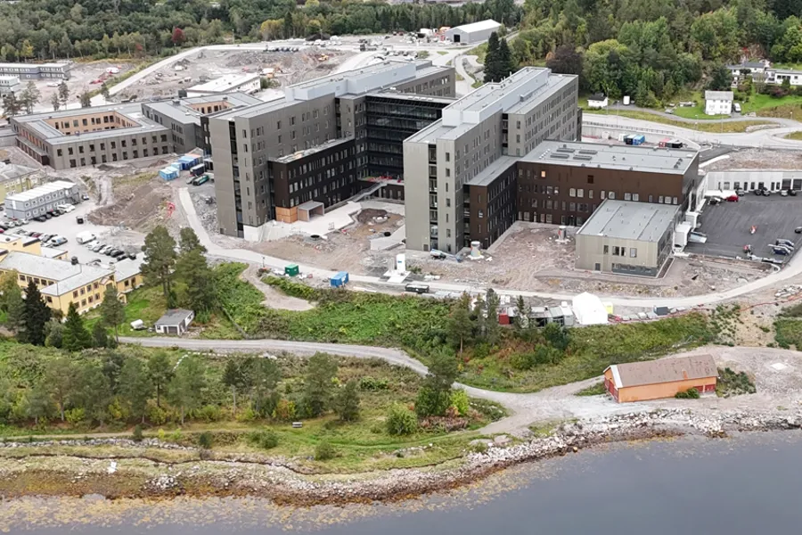 Dronebilde av Sjukehuset Nordmøre og Romsdal, Hjelset. Eit sjukehus ved fjorden. Arbeid med uteområdet gjenstår.